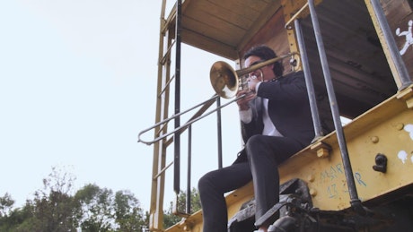 Musician playing his trombone alone.