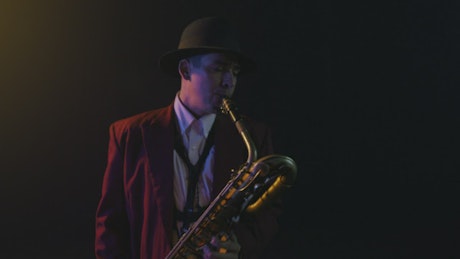 Musician playing the saxophone while dancing.
