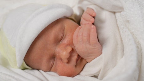 Newborn baby dreaming, face close up.