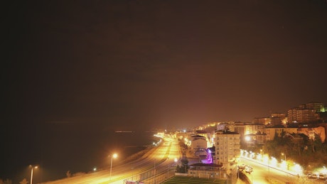Night to day time lapse of a city by the ocean