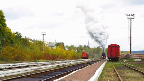 Old steam train arriving to the station.