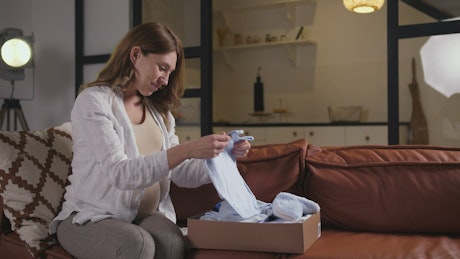 Opening a delivery of baby clothes