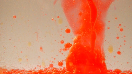 Orange ink bubbles in a water tank