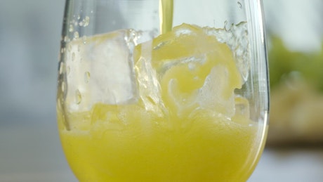 Orange juice poured over ice.