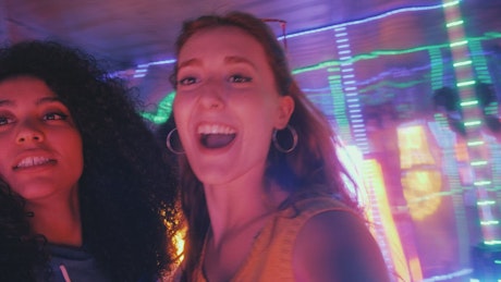 Pair of female friends having fun on a night out.