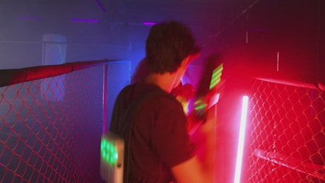 Pair of friends cleverly playing laser tag.