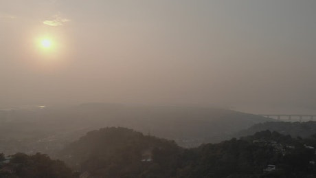 Panorama of a village between hills full of mist.