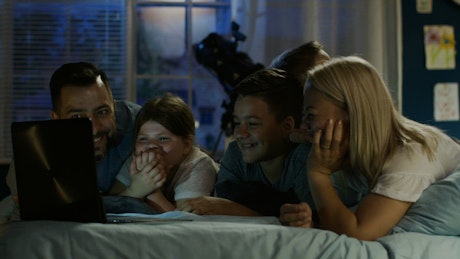 Parents and children watching movies on a laptop