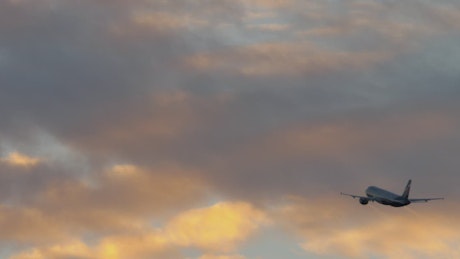 Passenger plane flying towards clouds.