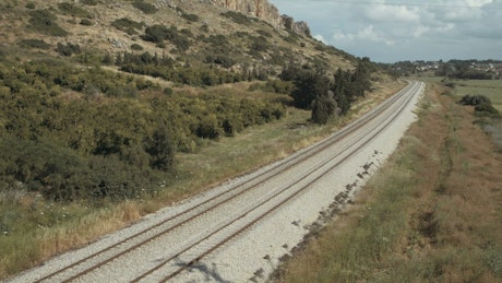 Passenger train running on tracks near the fields.