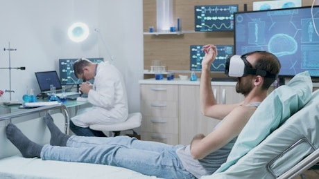 Patient looks at brain using VR technology in modern hospital.