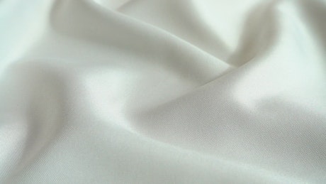 Pearls falling on white silk