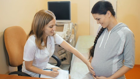 Pediatrician checks his patient's pregnancy