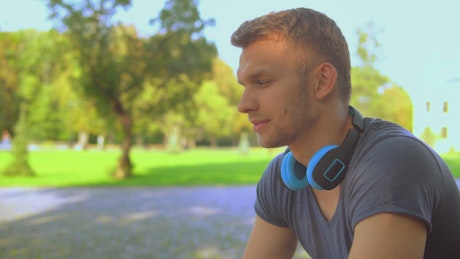 Pensive young man listening to music on his headphones