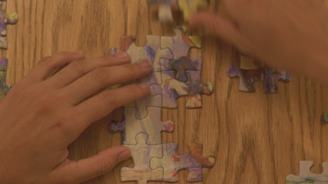 Person building a puzzle on a table