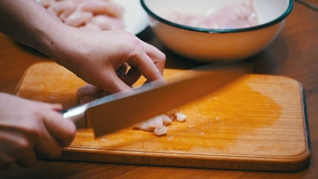 Person cutting meat into small pieces.