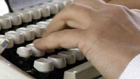 Person hands typing on typewriter.