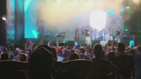 Person raising hands at a concert.