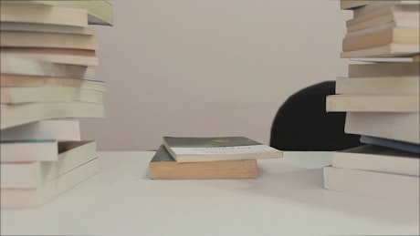 Person sits down to read surrounded by many books.