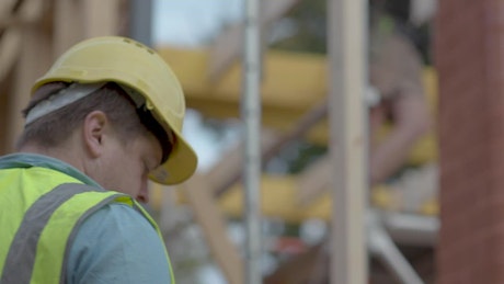 Person takes a phone call at a construction site.