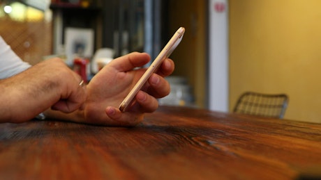 Person using a smartphone in a table