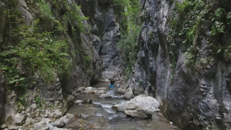 Person walking by a river in the mountains.