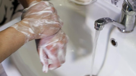 Person washing hands with soap.