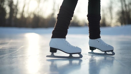 Person wearing ice skates sliding over the ice.