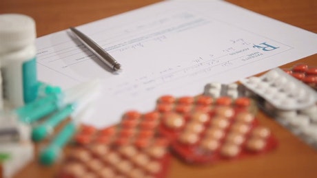 Pharmacist writes prescription for pills closeup.