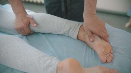 Physiotherapist working and massaging a woman's feet.