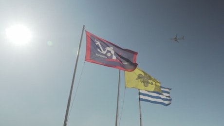 Plane flying past three flags