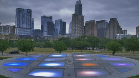 Platform with lights in a park within a big city.