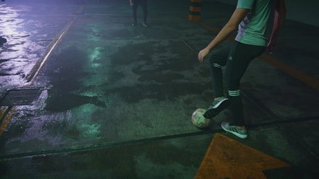 Player making skillful play in a street soccer game.