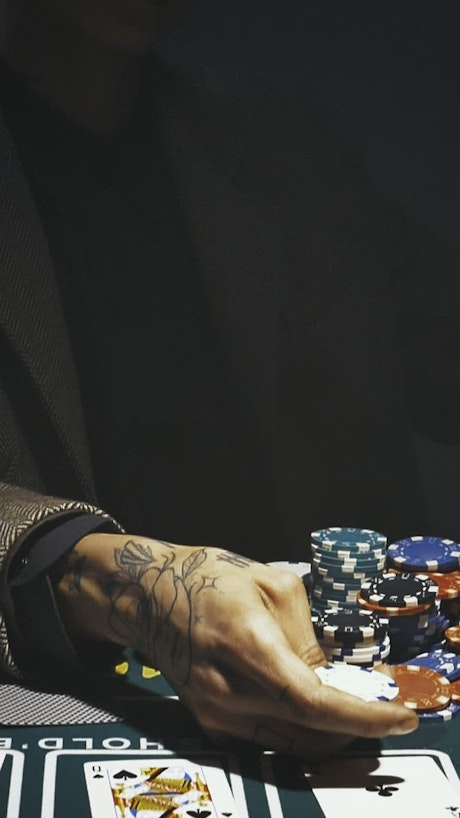 Poker player playing with a casino chip.