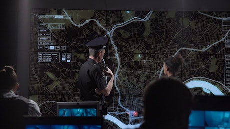 Policemen in front of an interactive map.