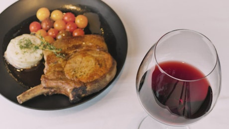 Pork chop and wine glass.
