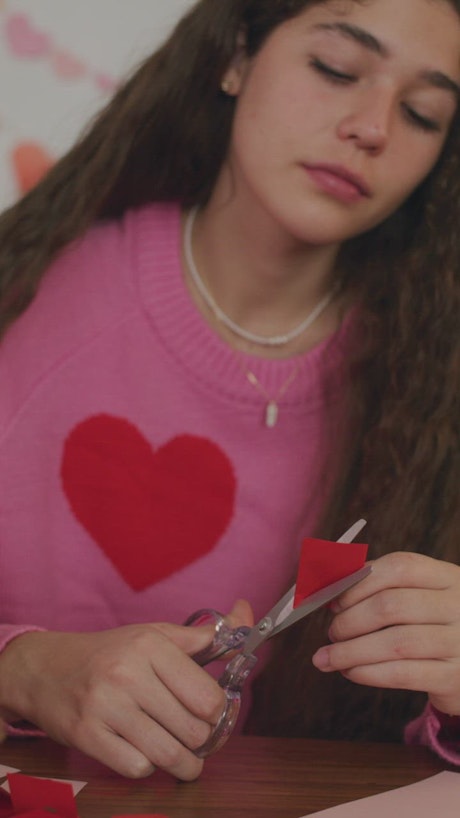 Portrait of a girl making a valentine card.