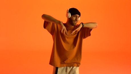 Portrait of a man dancing to the music in his headphones.