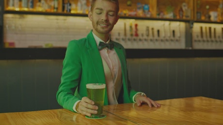 Portrait of a man drinking in a bar on Saint Patrick's Day.