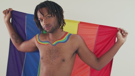 Portrait of a man wrapped in a pride flag