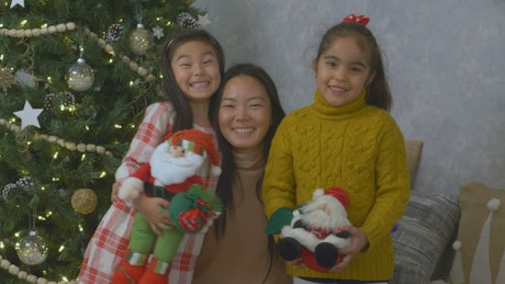 Portrait of a mother with her two little daughters at Christmas.