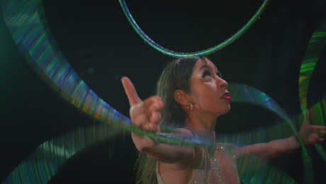 Portrait of a talented woman spinning various hula hoops.
