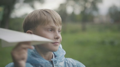 Portrait of little boy with a paper plane.
