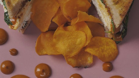 Potato chips and a halved sandwich