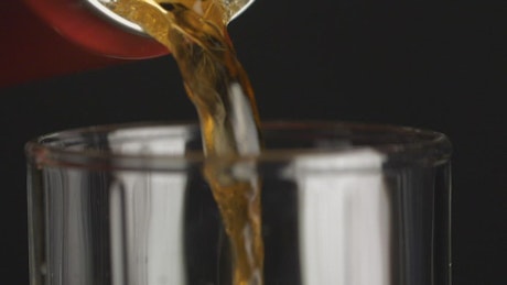 Pouring a can of soda into a glass