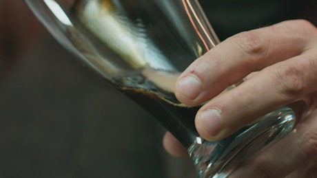 Pouring dark beer into a glass.