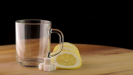 Pouring hot tea on a transparent cup.