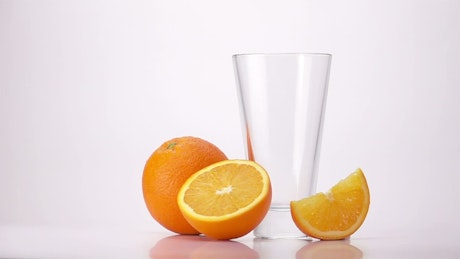 Pouring orange juice into a glass.