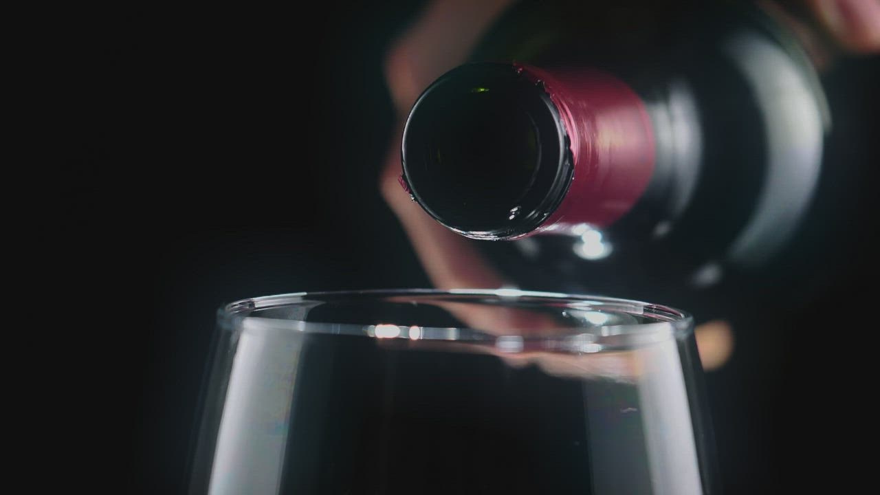 ⁣Pouring red wine  888slot link alternatif from a bottle, very close view