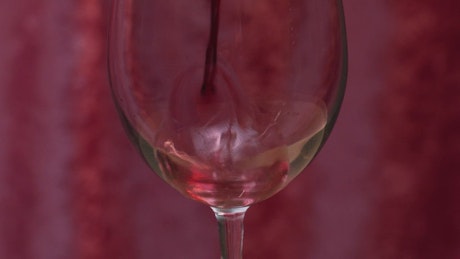 Pouring red wine into a glass.